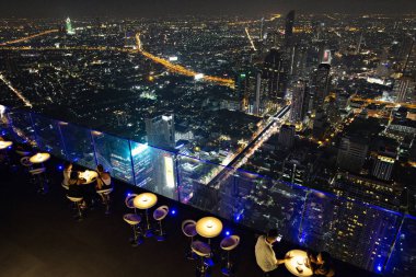 Bangkok, Tayland - Nisan 2019: Bangkok, Tayland 'daki King Power Mahanakhon gökdeleninin tepesindeki açık hava restoranında gece manzarası