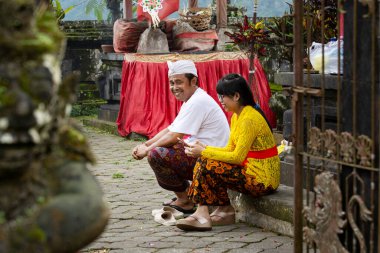 Balinese people traditionally dressed visiting temple for morning rituals, Ubud, Bali