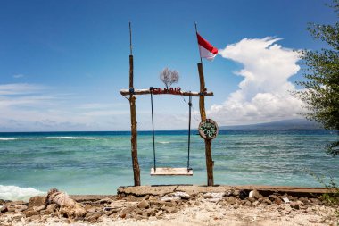 GILI HAVA, INDONESIA - Şubat 2020: Gili Air, Bali, Endonezya 'da ahşap mobilya, salıncak ve şemsiyeli konforlu plaj kafesi