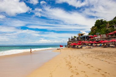 Deniz manzaralı plaj kafe ahşap mobilyalar ve şemsiyelerle Dreamland plajı, Bali, Endonezya