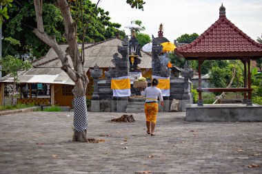BALI, INDONESIA - Şubat 2020: Balili kadın Endonezya, Bali tapınağındaki tanrılara bir sepet sundu.