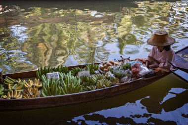İnsanlar Bangkok, Tayland 'a yakın Damnoen Saduak Yüzen Pazarı' nda sebze ve yiyecek satıyor.