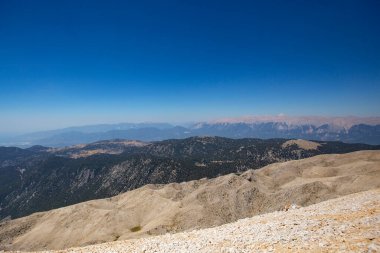 Dağlar mavi deniz ve doğa ile çevrili.
