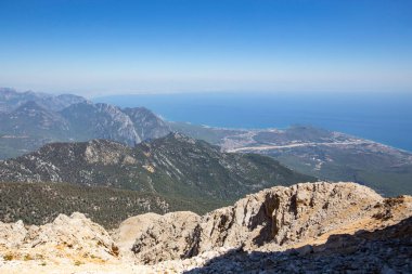 Mavi deniz arka planlı dağların gündüz görüntüsü