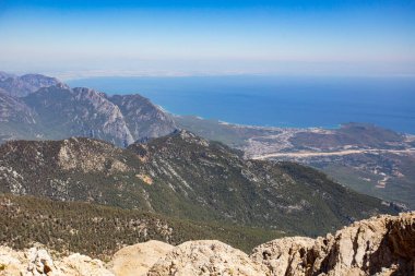 Mavi deniz arka planlı dağların gündüz görüntüsü