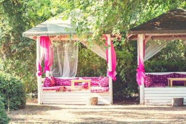 Yeşil bahçedeki lüks beyaz ve pembe bungalovlar