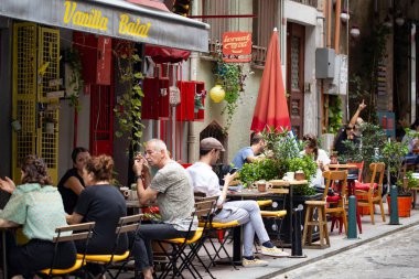 İSTANBUL, TURKEY - Eylül 2020: Dışarıda masaları olan rahat bir sokak kafesi, eski İstanbul, Balat 'taki kafelerde oturan ve konuşan insanlar.