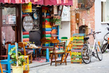 Dışarıda masaları olan rahat bir sokak kafesi, eski İstanbul 'un Balat bölgesinde oturan ve konuşan insanlar.