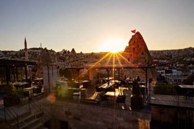 Goreme 'deki çatı üstü restoranı, insanların gün batımında yemek yemesi, Kapadokya, Türkiye