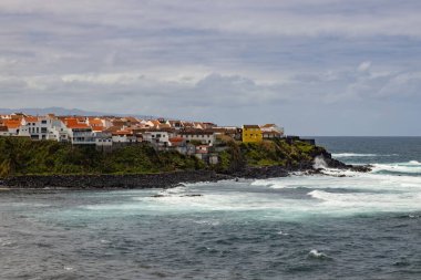 Portekiz 'in Azores adalarındaki Atlantik okyanus kıyısındaki uçurumlarda parlak evler