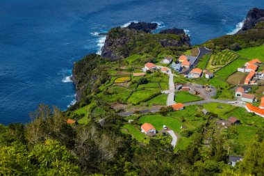 Portekiz 'in Azores adalarındaki Atlantik okyanus kıyısındaki uçurumlarda parlak evler