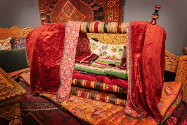 TASHKENT, UZBEKISTAN - 7 Eylül 2025: Özbek stili kumaşlarla süslenmiş geleneksel bebek beşiği Taşkent Özbekistan Uygulamalı Sanatlar Müzesi 'nde