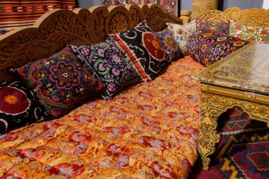 Dekoratif yastıklar ve seramik tabaklar sergilenen geleneksel Özbek oturma alanı, Özbekistan 'ın zengin kültür mirası ve sanatını yansıtıyor