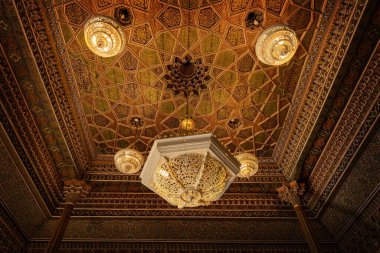 TASHKENT, UZBEKISTAN - 7 Eylül 2025: Taşkent Özbekistan 'daki Uygulamalı Sanatlar Müzesinde avizelerle oyulmuş geleneksel ahşap ve mozaik tavan