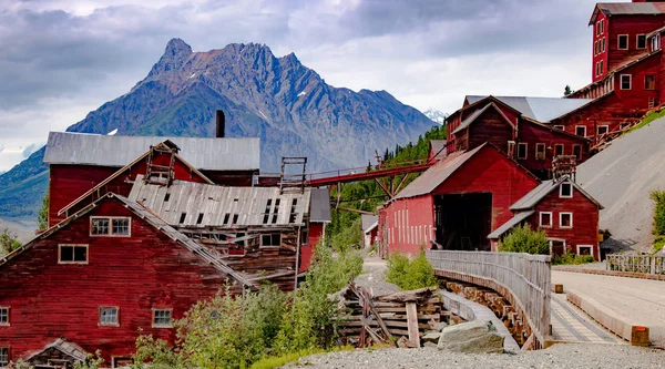 Abandoned copper mine rises red above the mountains in McCarthy Alaska.