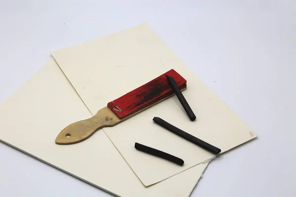 Kreslení uhlí, brusný papír pro zostření a listy papíru s několika řádky v uhlí. — Stock fotografie