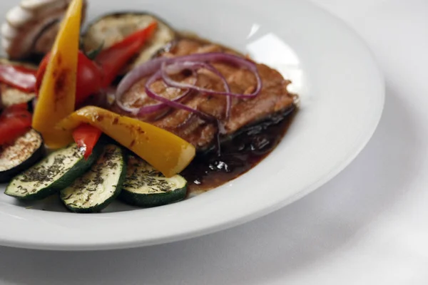 Filete de salmón a la parrilla y verduras a la parrilla en un plato de porcelana blanca . —  Fotos de Stock