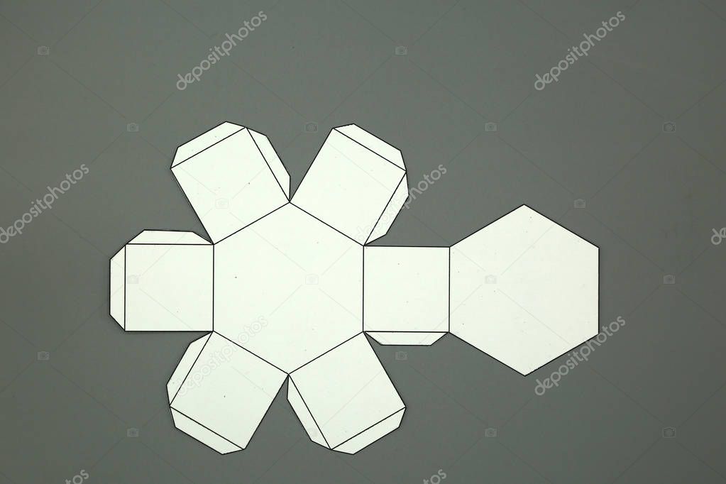 Geometric shape cut out of paper and photographed on white background.Hexagonal prism. 2D shapefoldable to form a 3-dimensional shape or a solid.