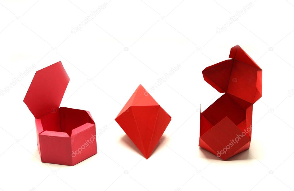 Geometric shape cut out of red paper and photographed on white. Hexagonal Dipyramid, Hexagonal prism, Cuboctahedron Geometry net. Unfolded three Dimensional Figures