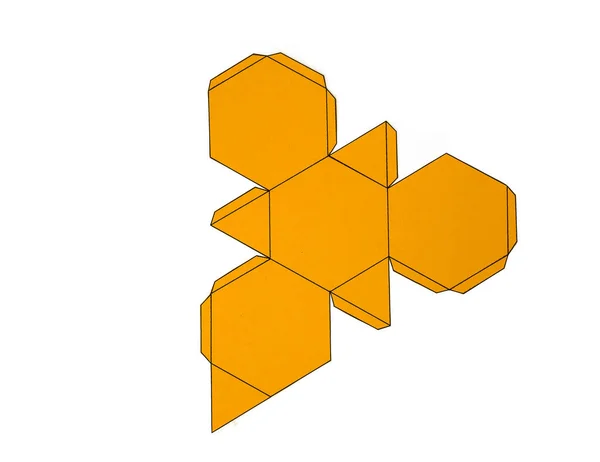Forma geométrica cortada de papel amarillo y fotografiada desde arriba sobre fondo blanco.Red geométrica de tetraedro truncado. Se desplegaron figuras tridimensionales. Aislado. Vista superior . — Foto de Stock