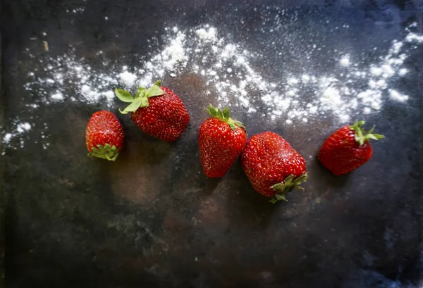Ripe, red strawberries with powered icing sugar on a dark background . Top view with copy space — Stock Photo, Image