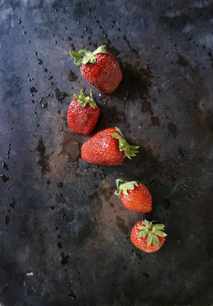 Mogna, röda jordgubbar med vattendroppar och stänk på en mörk bakgrund. Övervy med kopierings utrymme — Stockfoto
