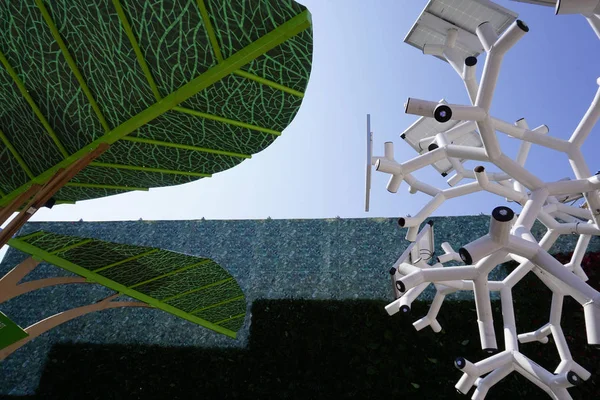 Smart charging solar panels tree. The tree uses energy stored by the solar panels to provide USB charging Wi-Fi, lighting .White structure on green background.