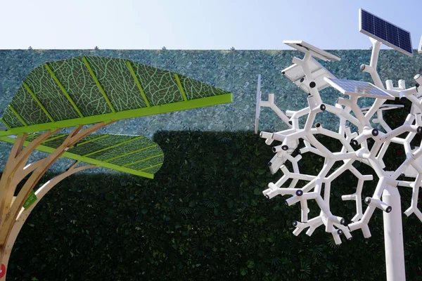 Smart charging solar panels tree. The tree uses energy stored by the solar panels to provide USB charging Wi-Fi, lighting .White structure on green background.