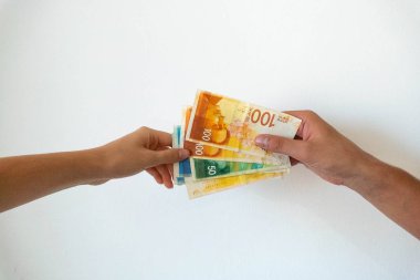 İnsanlar şekelleri elden ele gezdirir.