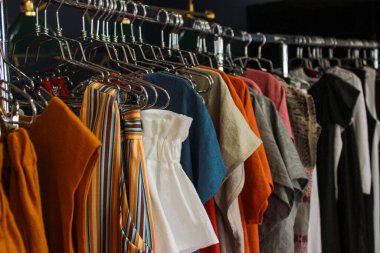 Gardıroptaki askılarda asılı kadın kıyafetleri.