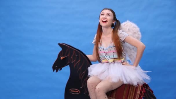 Menina bonita monta um cavalo de brinquedo — Vídeo de Stock