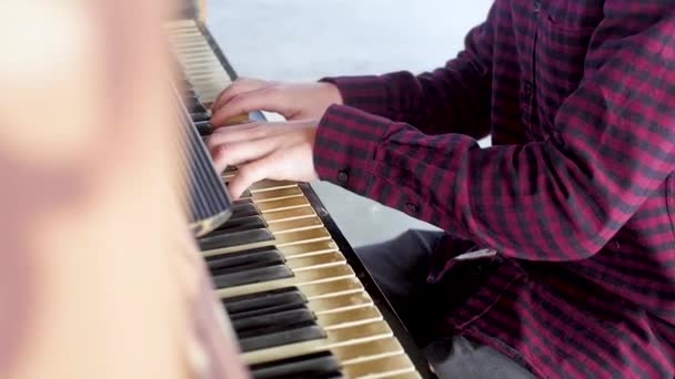 Een jonge man speelt met zijn handen op de piano — Stockvideo