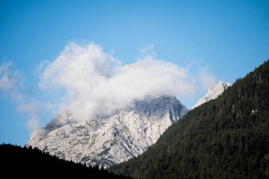 Wetterstein dağlarının zirveleri sabahın erken saatlerinde bulutlarda, Almanya 'nın Mitenwald şehrinden manzara