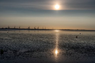 Kuzey Denizi 'nin çorak sularında gün batımında Tossen, Almanya yakınlarında.