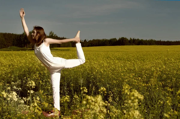 Beautiful girl practices yoga in peaceful nature atmosphere