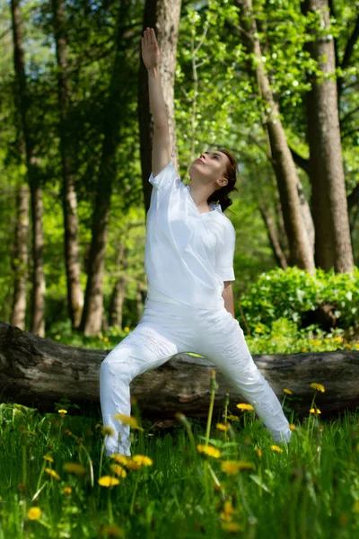 Beautiful girl practices yoga in peaceful nature atmosphere