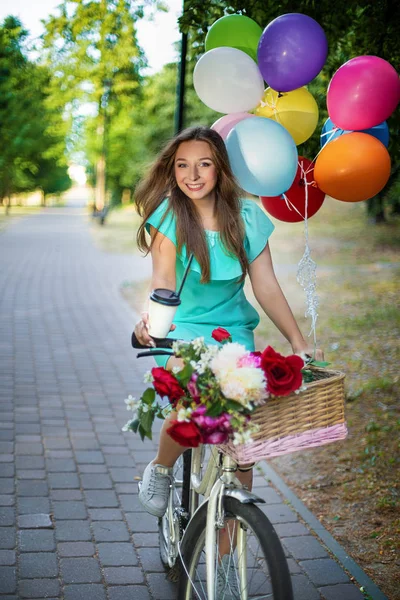 beautiful fashion girl with bicycle and balloons and coffe