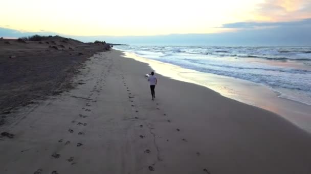 Aerial Panorering Med Drönare Ung Attraktiv Man Jogga Stranden Soluppgången — Stockvideo