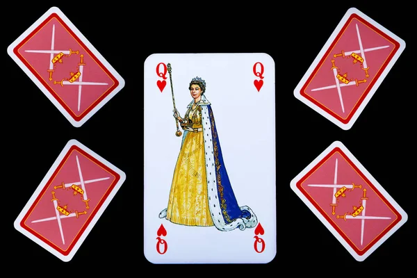 Close up of playing cards. Queen of hearts and four inverted cards. Isolated on black background.