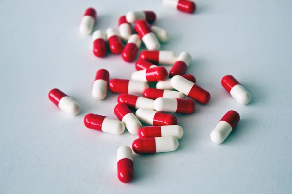 Pílulas vermelhas e brancas em um fundo branco — Fotografia de Stock