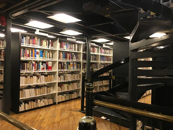 Bookshelfs in the public library filled with lots of books and a — Stock Photo, Image