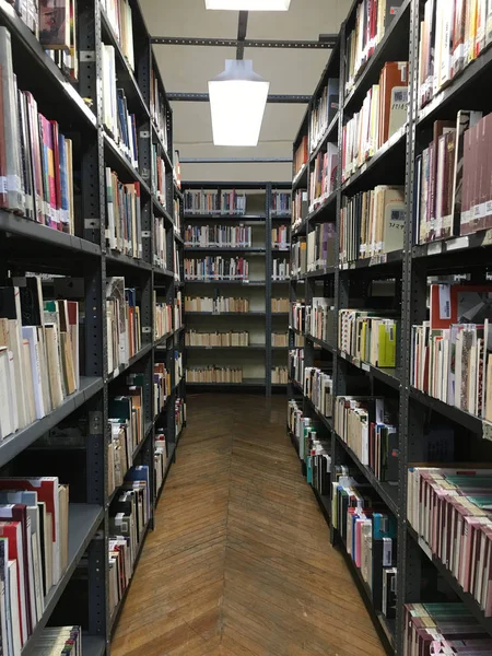 Étagères dans la bibliothèque publique remplie de beaucoup de livres — Photo