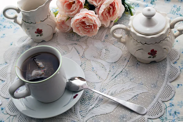 Cup of tea and the tea set some flowers,