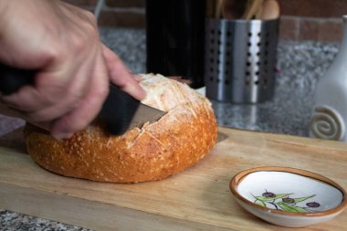 Yemek hazırlamak için bir somun ekmek dilimliyorum.