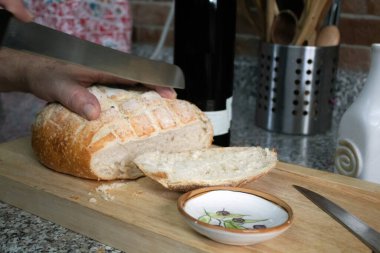 Yemek hazırlamak için bir somun ekmek dilimliyorum.