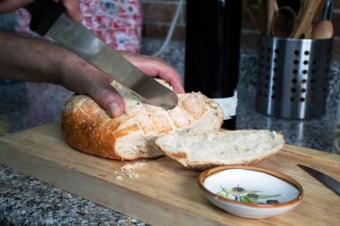 Yemek hazırlamak için bir somun ekmek dilimliyorum.