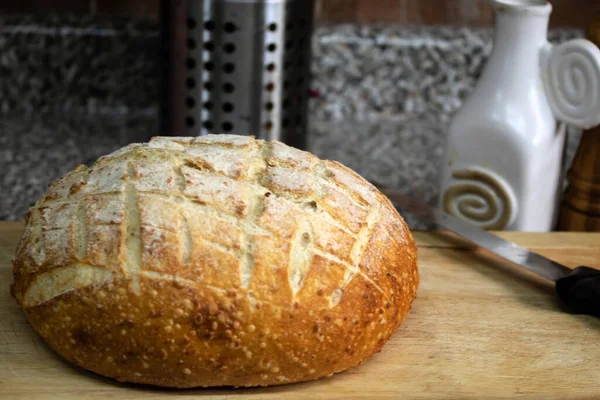 Round loaf of bread ready for a meal prep ina cutting board at the kitchen