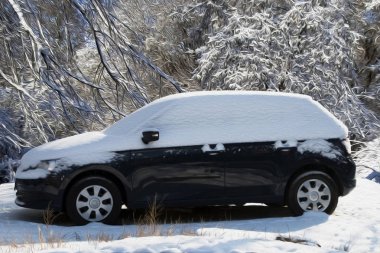 Mavi araba karla kaplı ve dondurulmuş.
