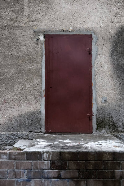 Red metal door in an abandoned house.