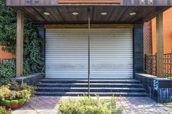 Kapalı metal perdeler ile eski terk edilmiş otel restoranı.